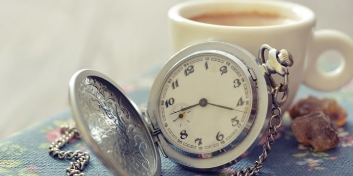 一个怀表和一杯咖啡在桌子上